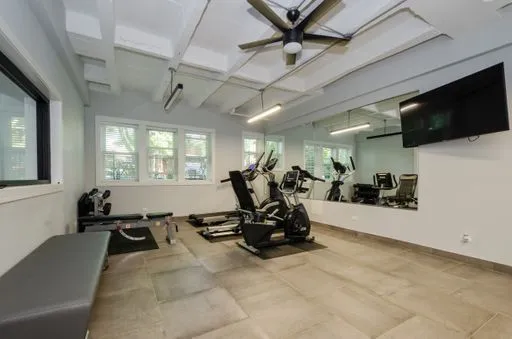 a living room with furniture gym equipment and a flat screen tv
