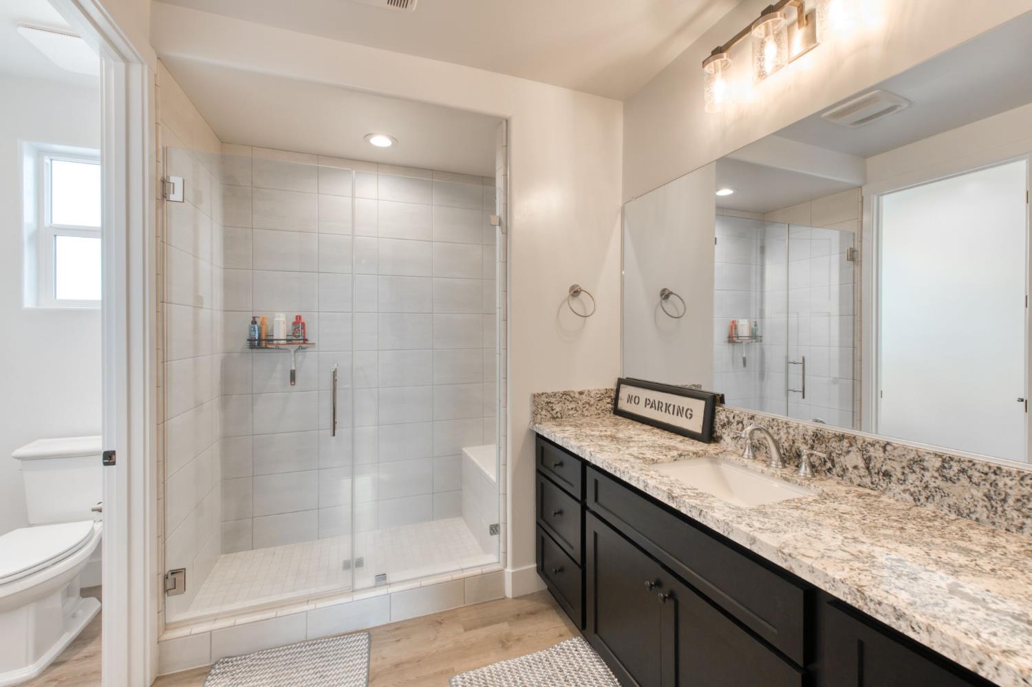 1736 North Renn Avenue Clovis, CA 93619 - Photo 29 of 66 a bathroom with a granite countertop sink a toilet and shower