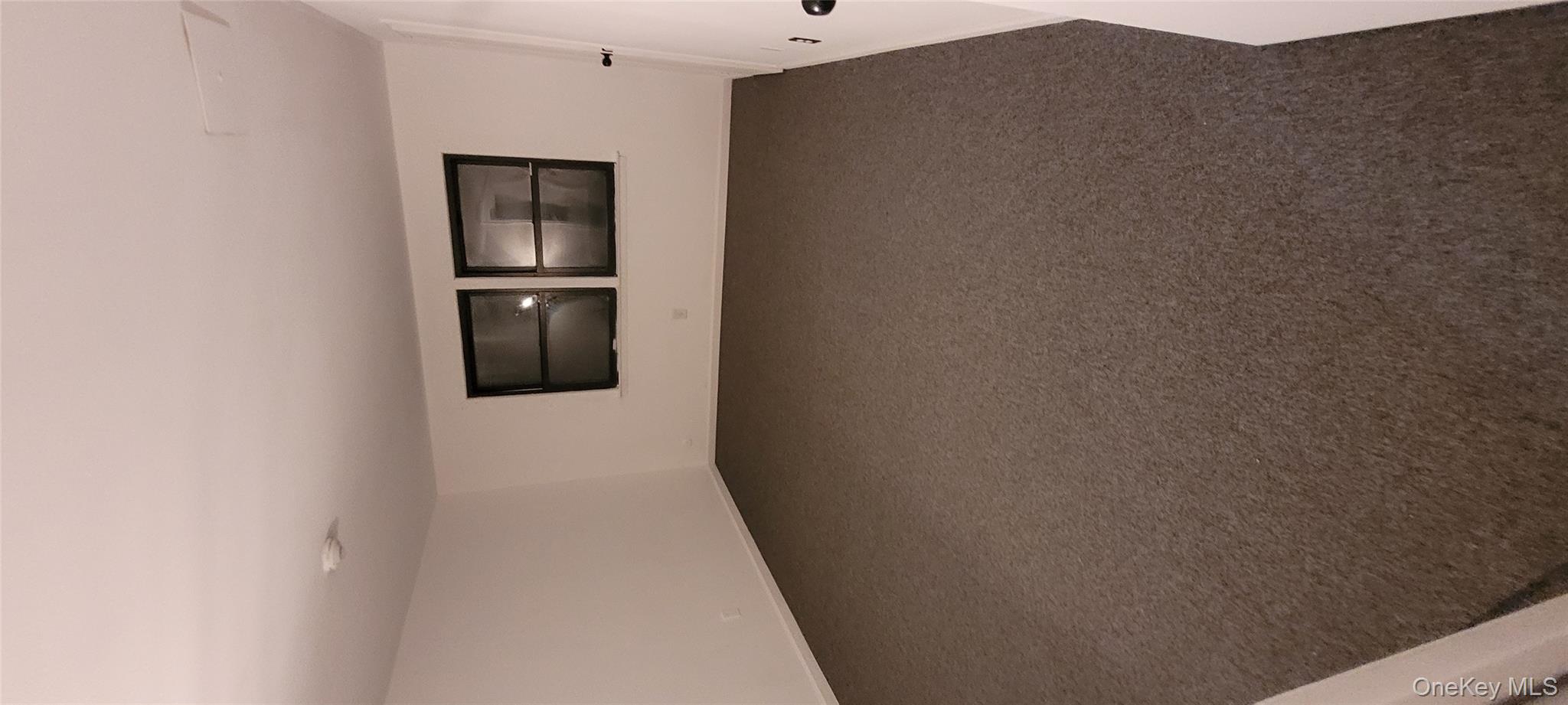 2 Williamsburg Court, Unit C Ridge, NY 11961 - Photo 19 of 20 Spare room with dark carpet