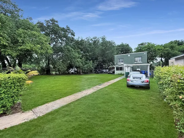 a front view of a house with a garden and trees