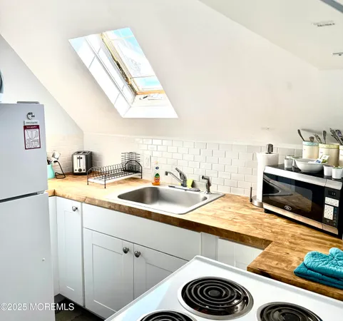 a white refrigerator freezer and a stove sitting inside of a kitchen