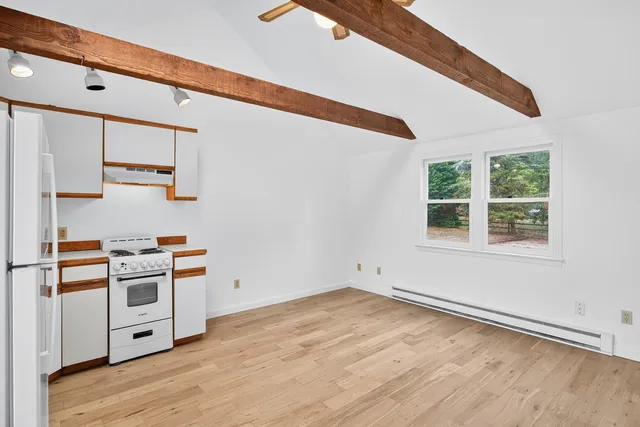 a kitchen with a stove and a wooden floor