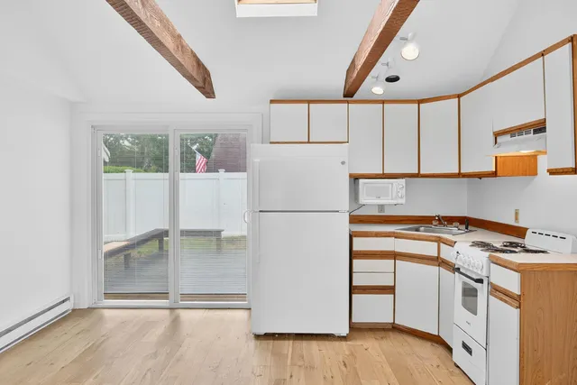 a white refrigerator freezer and a stove sitting inside of a kitchen