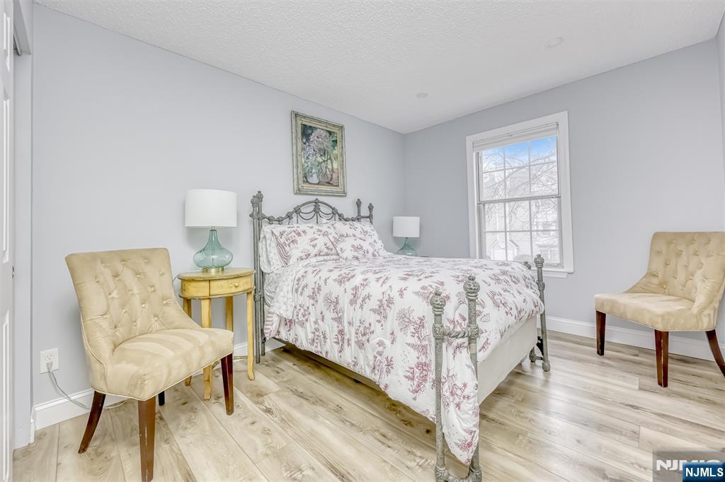 667 Juniper Way, Unit 667 Mahwah, NJ 07430 - Photo 12 of 14 a bedroom with a bed a chair and a potted plant on table