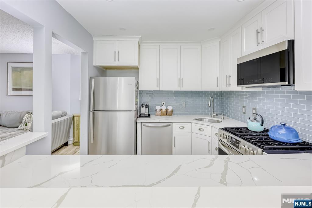 667 Juniper Way, Unit 667 Mahwah, NJ 07430 - Photo 6 of 14 a kitchen with stainless steel appliances granite countertop a refrigerator sink stove and microwave