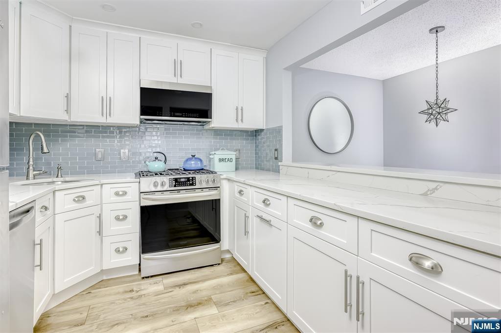 667 Juniper Way, Unit 667 Mahwah, NJ 07430 - Photo 7 of 14 a kitchen with white cabinets stainless steel appliances and sink