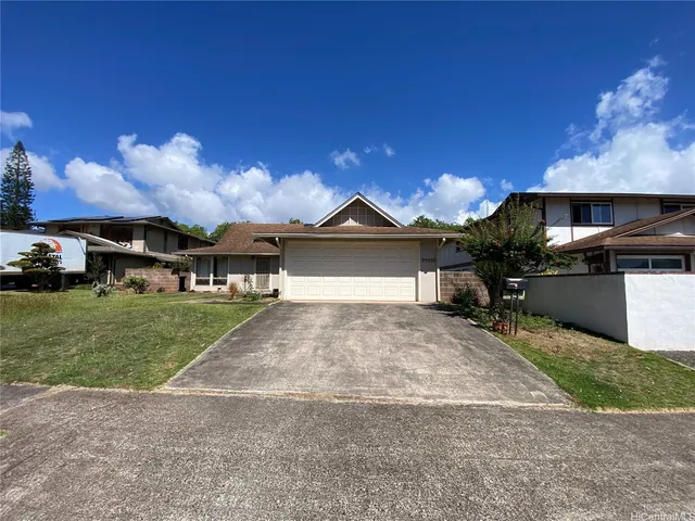 a front view of a house with a yard and a garage