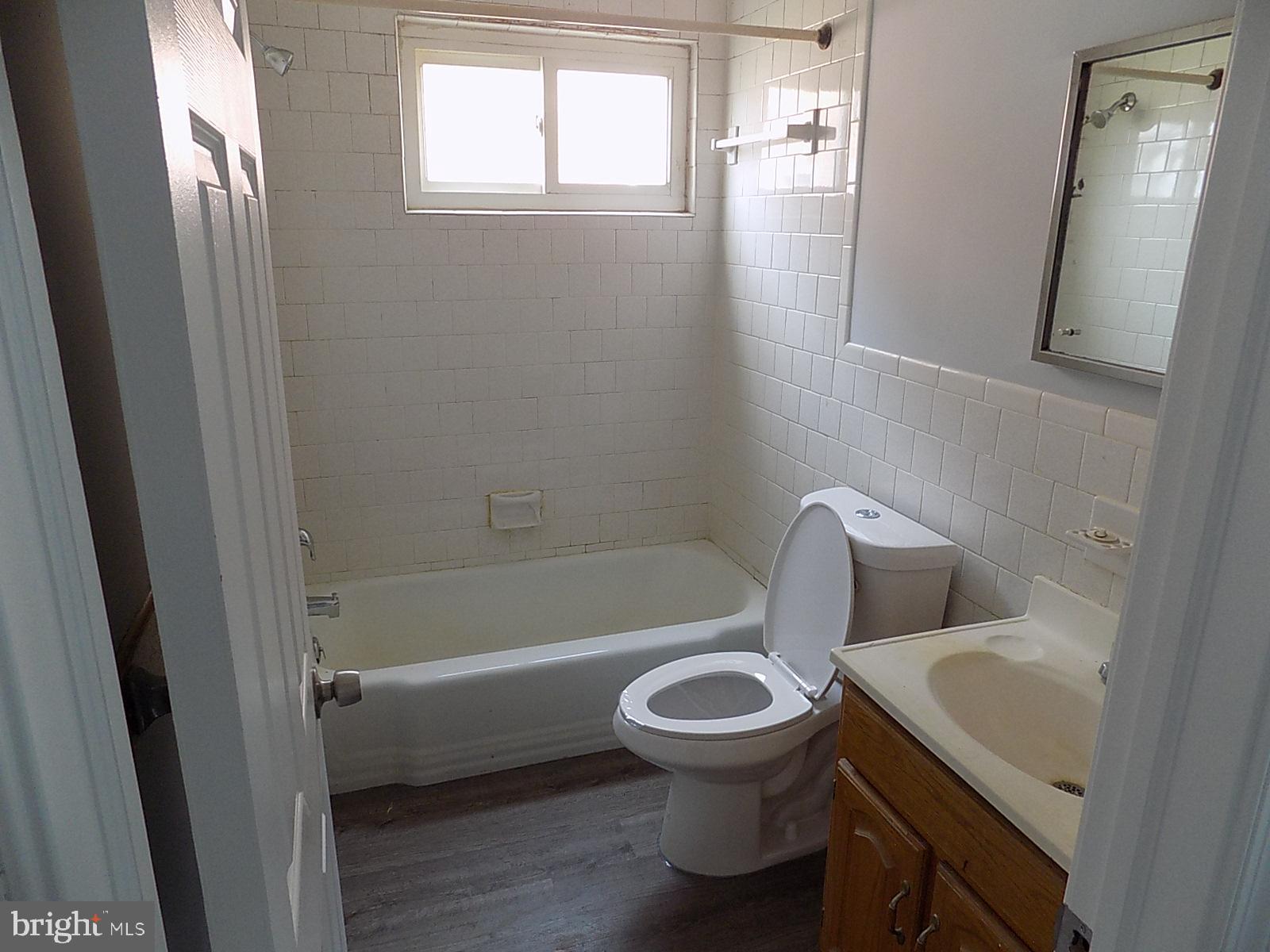 9902 Harford Road Baltimore, MD 21234 - Photo 11 of 13 a white toilet sitting next to a bathroom sink