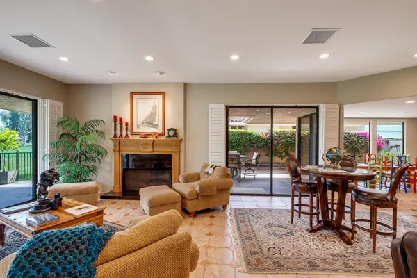 a living room with furniture a fireplace and a floor to ceiling window