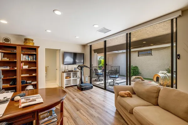 a living room with furniture a flat screen tv and a table