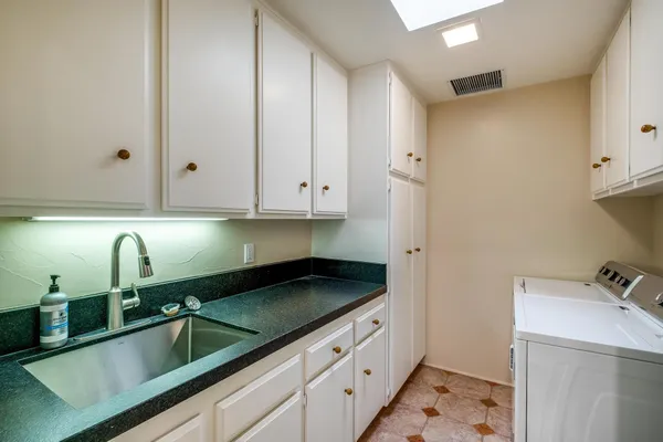 a kitchen with granite countertop white cabinets and sink