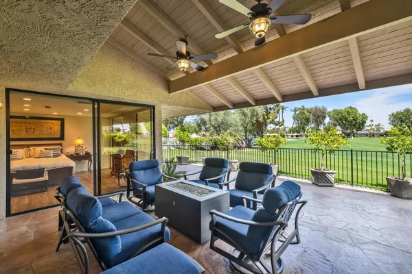a living room with patio furniture and a floor to ceiling window