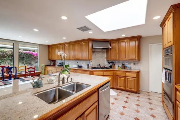 a kitchen with stainless steel appliances granite countertop a sink a stove and a refrigerator