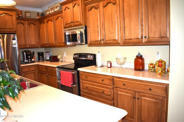 a kitchen with stainless steel appliances granite countertop a sink dishwasher stove and cabinets