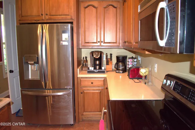 a kitchen with stainless steel appliances granite countertop a refrigerator and a stove