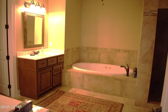 a bathroom with a bathtub sink and mirror