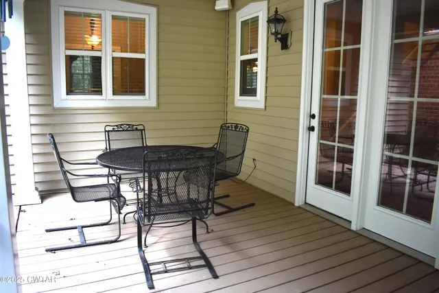 a patio with table and chairs and wooden floor