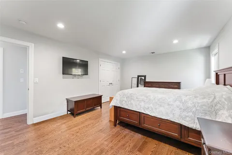a spacious bedroom with a bed and a flat screen tv