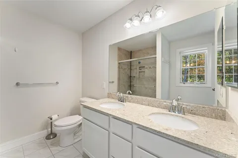 a bathroom with a granite countertop sink a toilet and a mirror