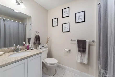 a bathroom with a granite countertop toilet sink and mirror