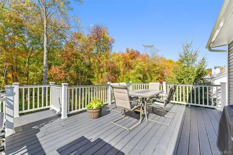a balcony with wooden floor table and chairs