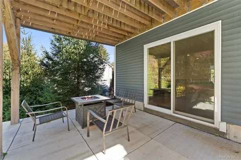 a patio with a table and chairs and potted plants