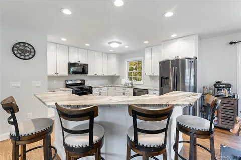 a kitchen with a dining table chairs and refrigerator