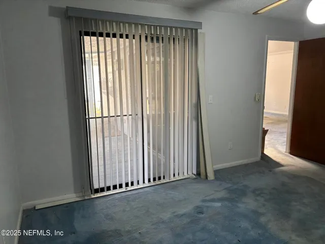 an empty room with closet and a chandelier fan