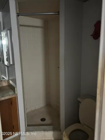 a bathroom with a toilet and a shower
