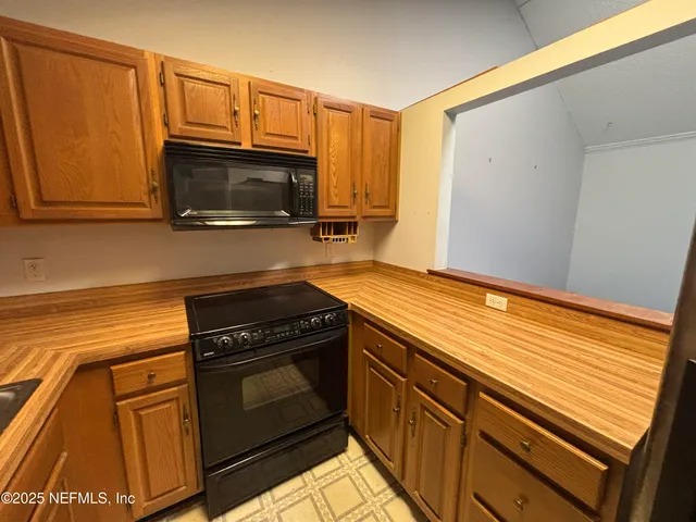 a kitchen with granite countertop cabinets stainless steel appliances and a wooden floor