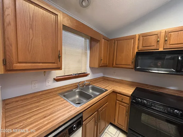 a kitchen with granite countertop cabinets stainless steel appliances and a wooden floor