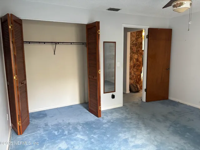 an empty room with closet and a glass door