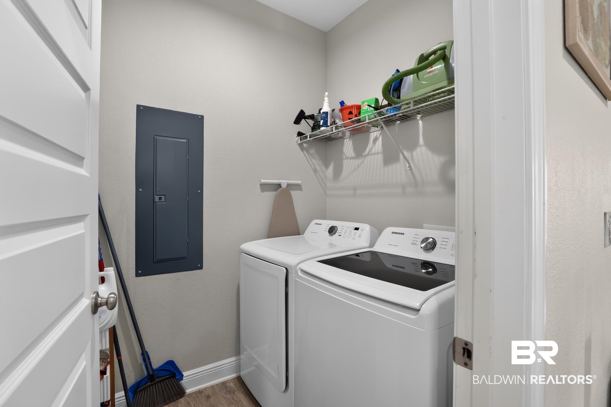 1210 Primrose Lane Foley, AL 36535 - Photo 25 of 33 Dedicated laundry area featuring a washer and dryer, wire shelving, and wood-finish flooring
