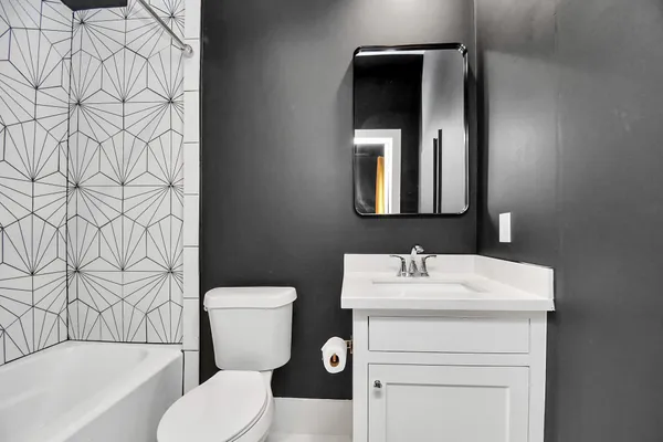 a bathroom with a toilet sink and mirror