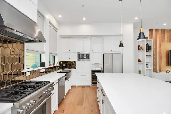 a kitchen with stainless steel appliances a stove a sink a refrigerator and a oven