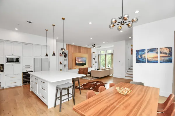 a large white kitchen with a large center island and stainless steel appliances