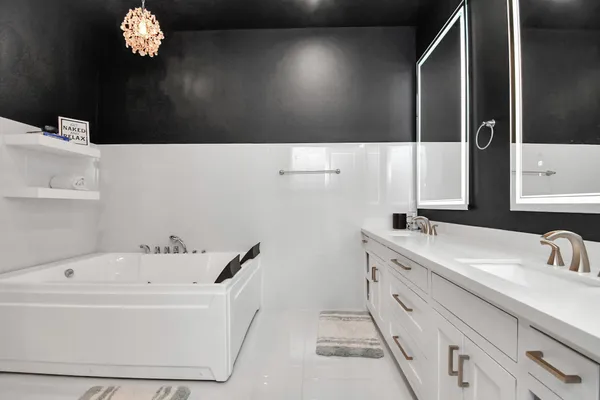 a bathroom with a sink a large mirror and a bathtub