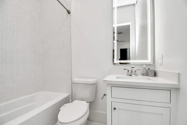 a bathroom with a sink toilet vanity and tub