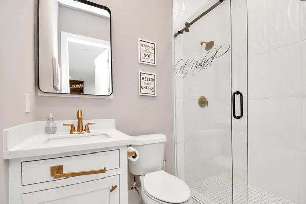 a bathroom with a sink a toilet and a mirror