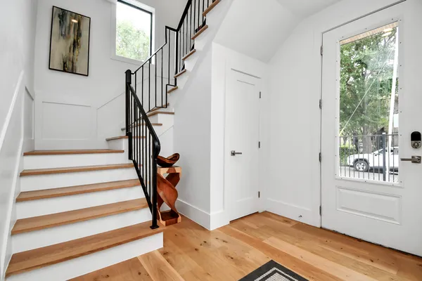 a view of entryway with wooden floor and front door