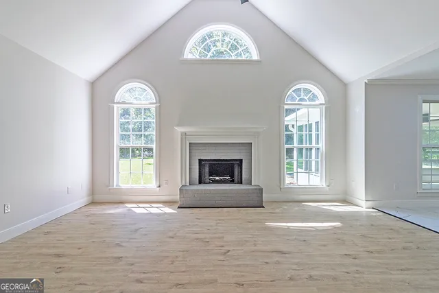 a view of an empty room with a window and a fireplace