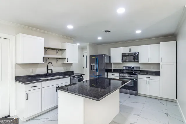a kitchen with stainless steel appliances a stove a sink a stove a microwave and cabinets
