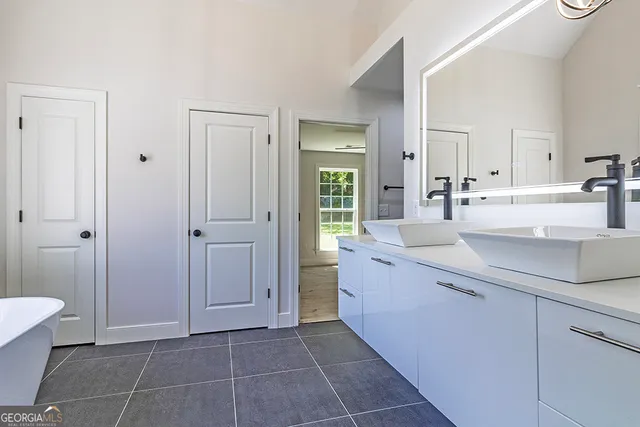 a large bathroom with a tub sink and mirror