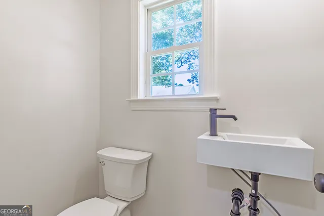 a bathroom with a toilet a sink and a window