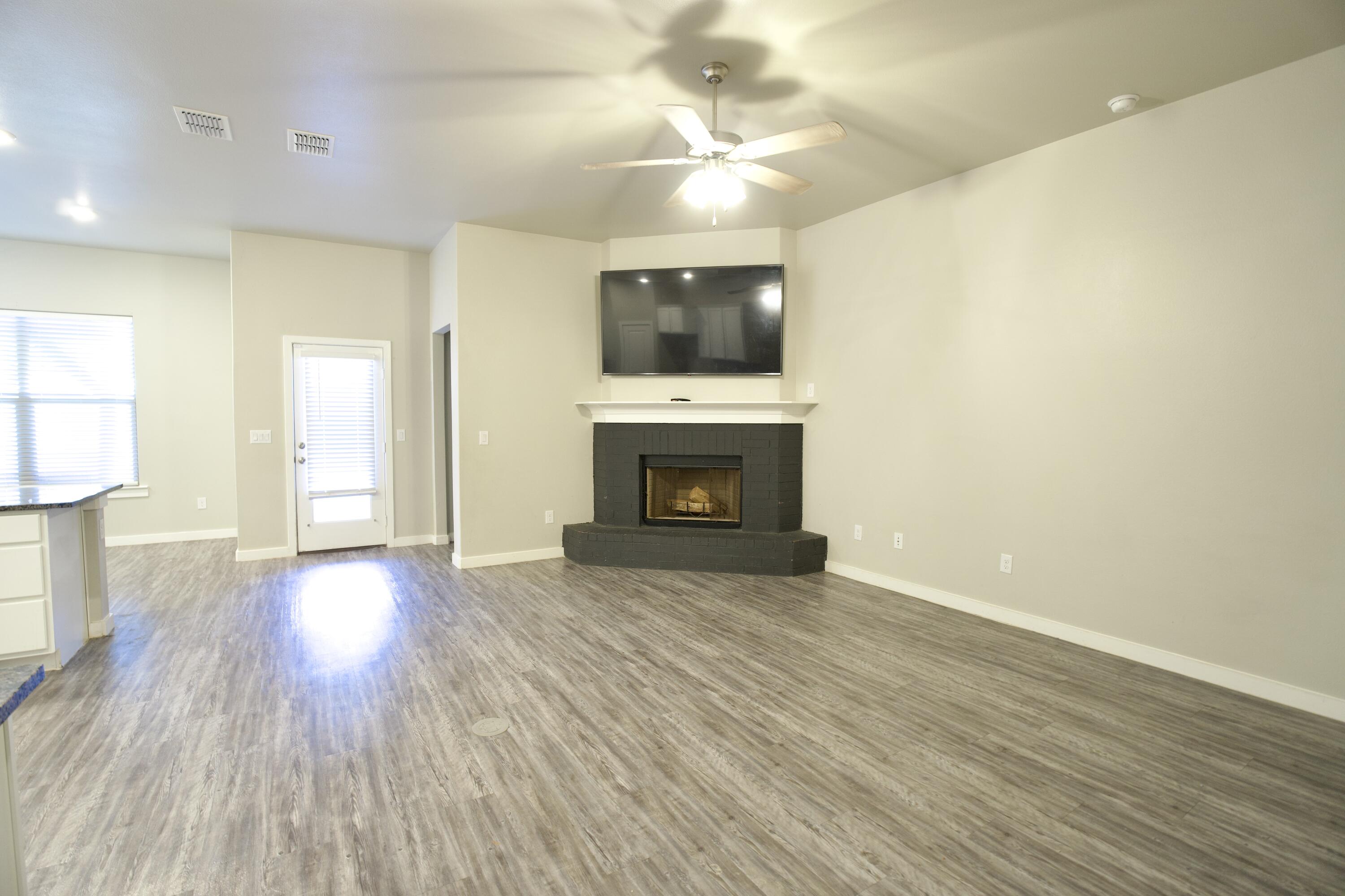 1604 137th Street Lubbock, TX 79423 - Photo 3 of 19 a view of an empty room with a fireplace and a window