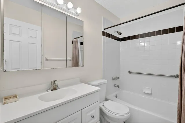 an empty room with a chandelier fan and windows