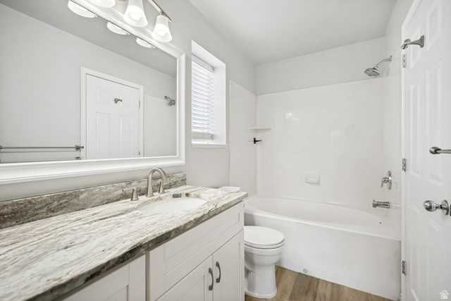 5529 Ridge Hollow Way Kearns, UT 84118 - Photo 15 of 23 Bathroom featuring a white vanity with panel-front cabinetry, a stone countertop, an undermount sink, and a brushed nickel faucet