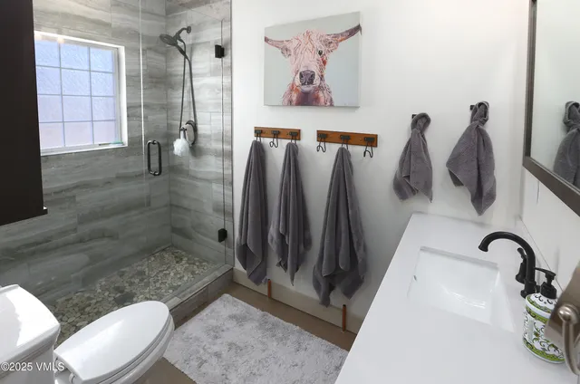 a bedroom with a bed dresser with a flat screen tv and a fireplace