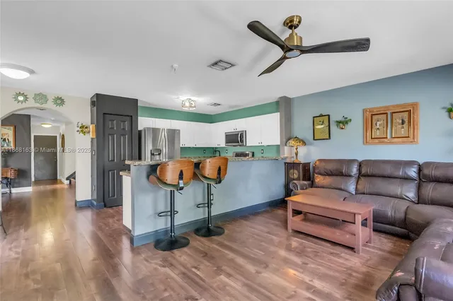a living room with furniture and kitchen view