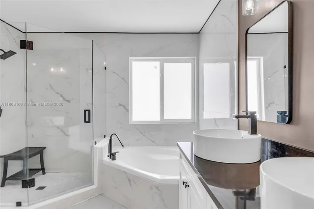 a bathroom with a tub sink and mirror